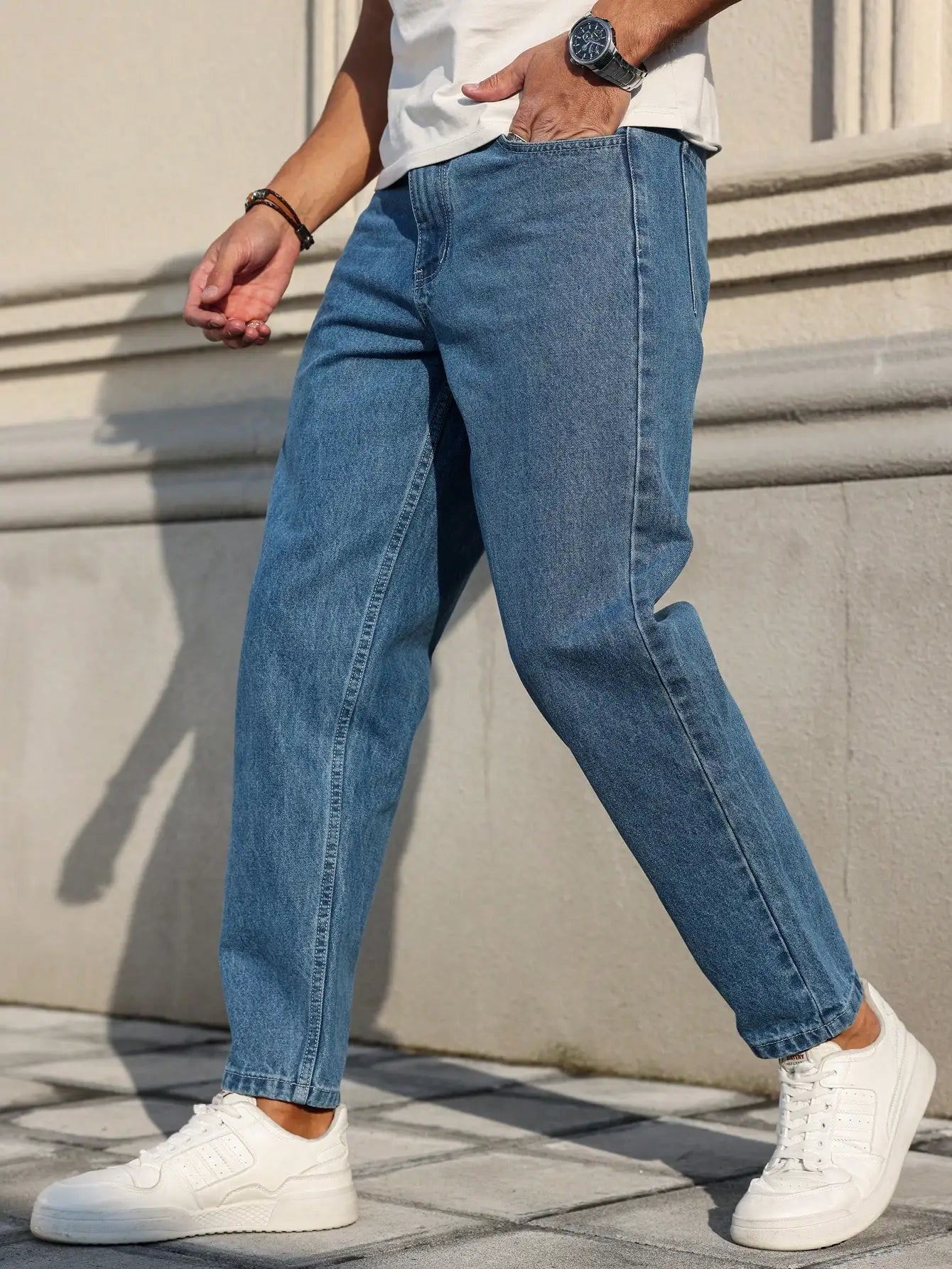 Men's jeans are made of classic blue denim fabric with a loose fit, making them an indispensable versatile item in the wardrobe.